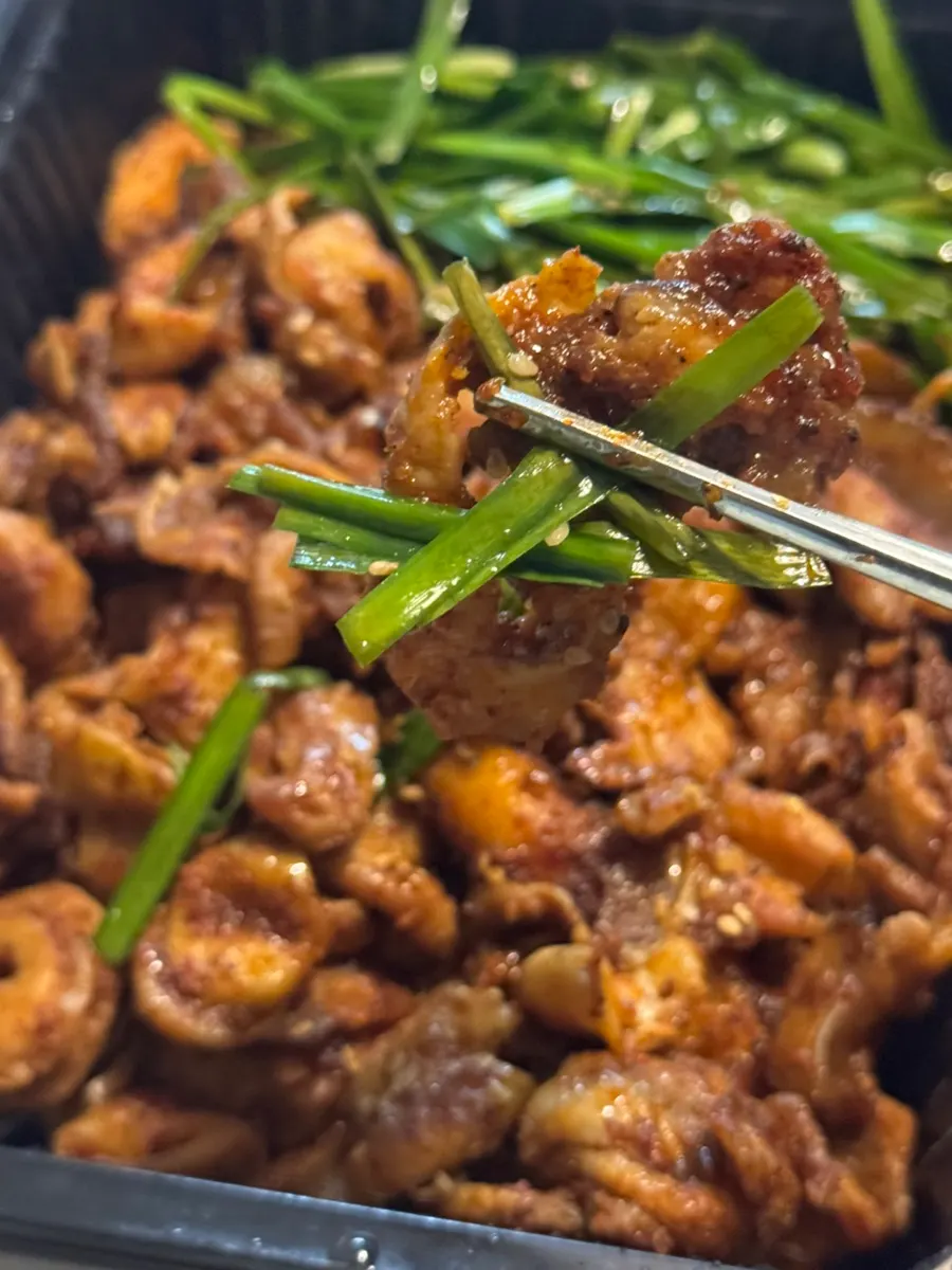 A piece of charcoal-grilled gopchang coated in sauce