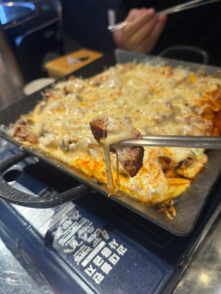 쭉 늘어나는 치즈에 묻힌 곱창 한 점