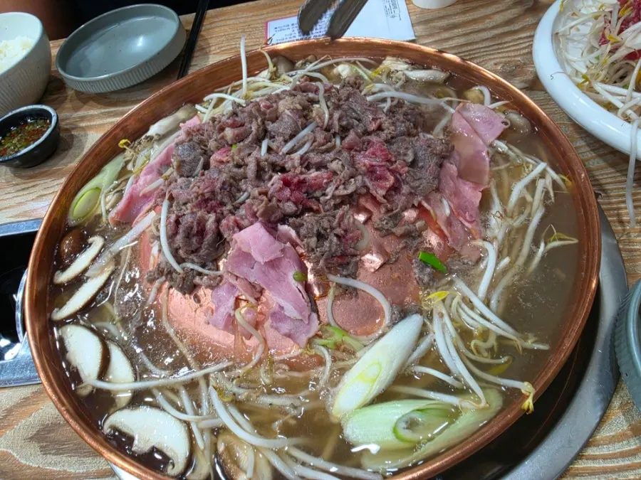 A bite of beef bulgogi dipped in the sauce