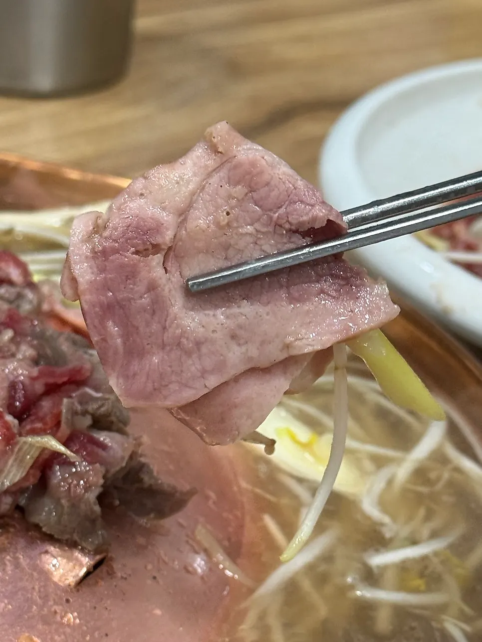 A bite of bulgogi eaten with bean sprouts