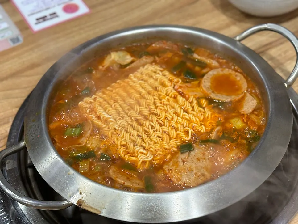 Budae jjigae broth with a bowl of rice