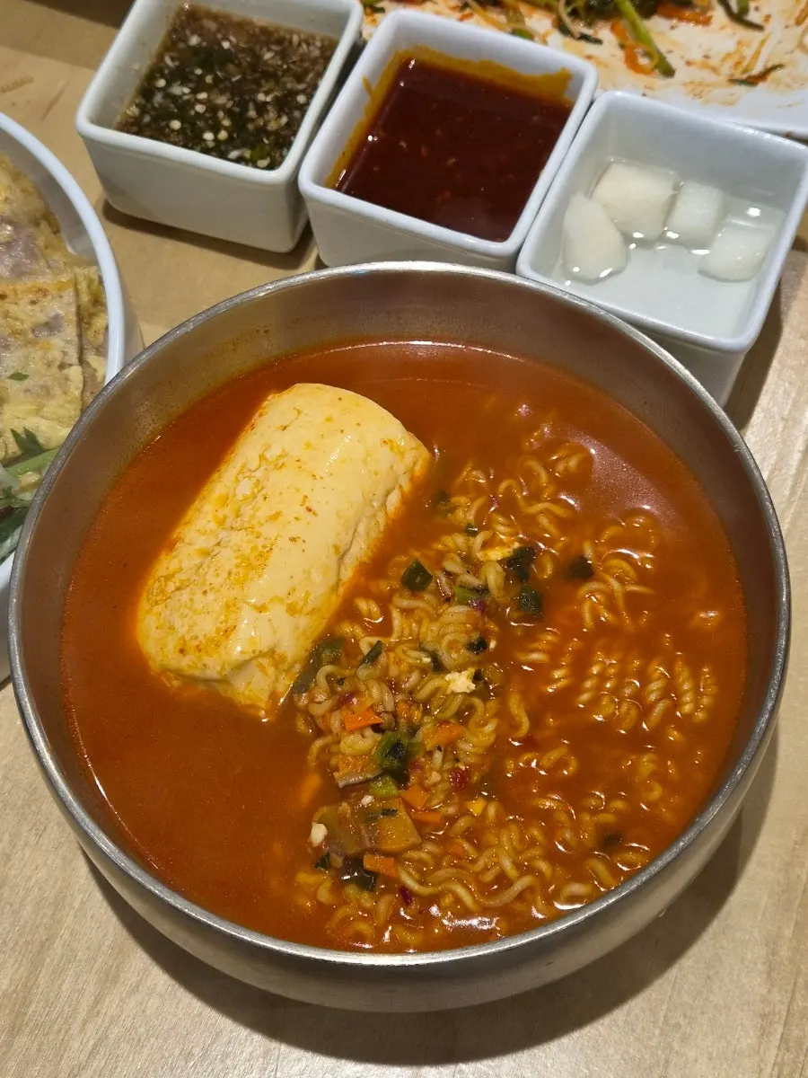 A pot of spicy sundubu yeolramyeon