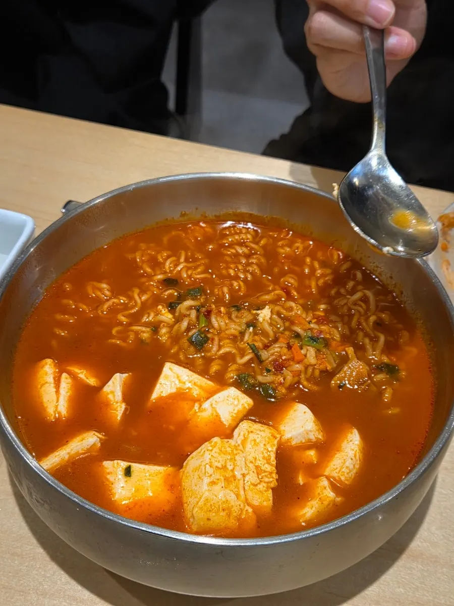 Scooping up soft tofu and broth from the yeolramyeon