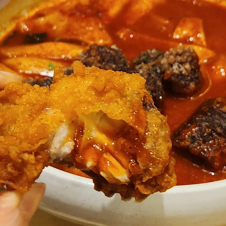 A piece of fried chicken showing the meat inside