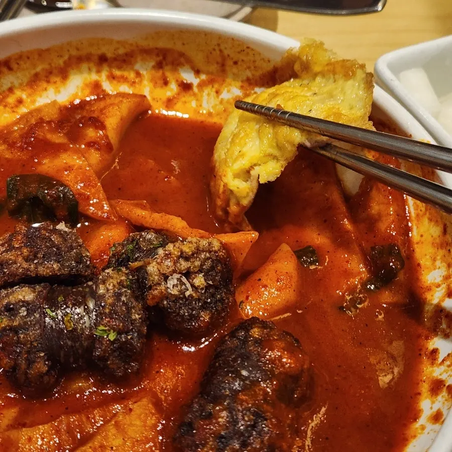 A piece of yukjeon coated with tteokbokki sauce
