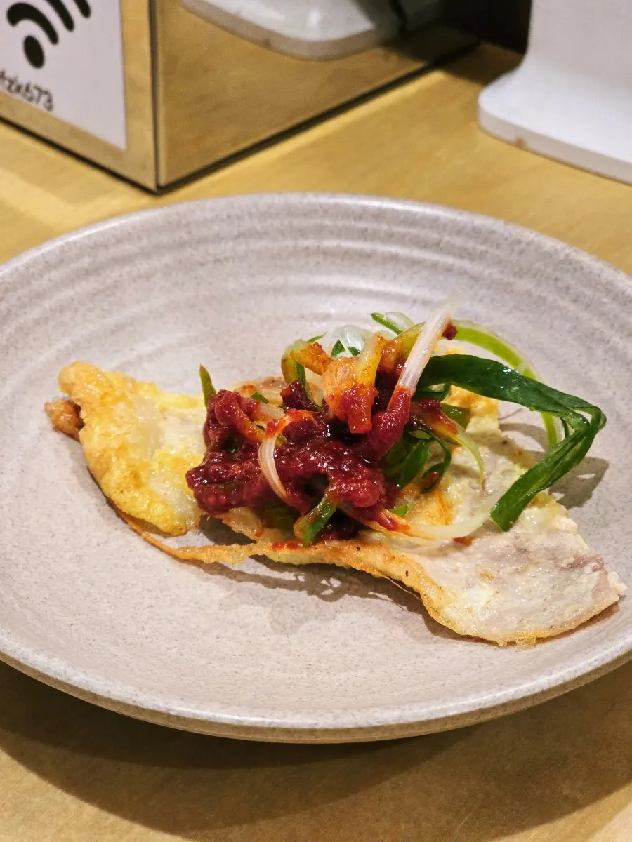 A piece of jeon with sweet-and-spicy shredded scallions