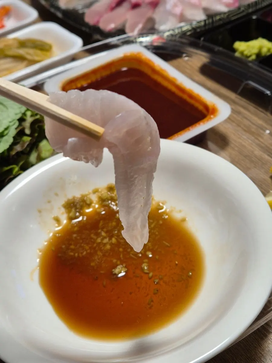 A piece of sashimi dipped in Bongpo Hoega's homemade ssamjang