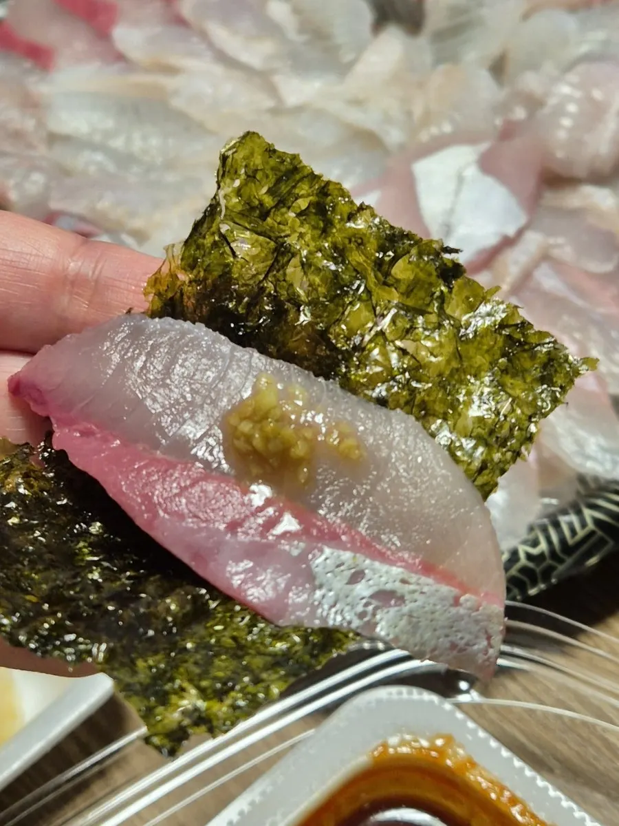 Red fish sashimi placed on top of seasoned seaweed