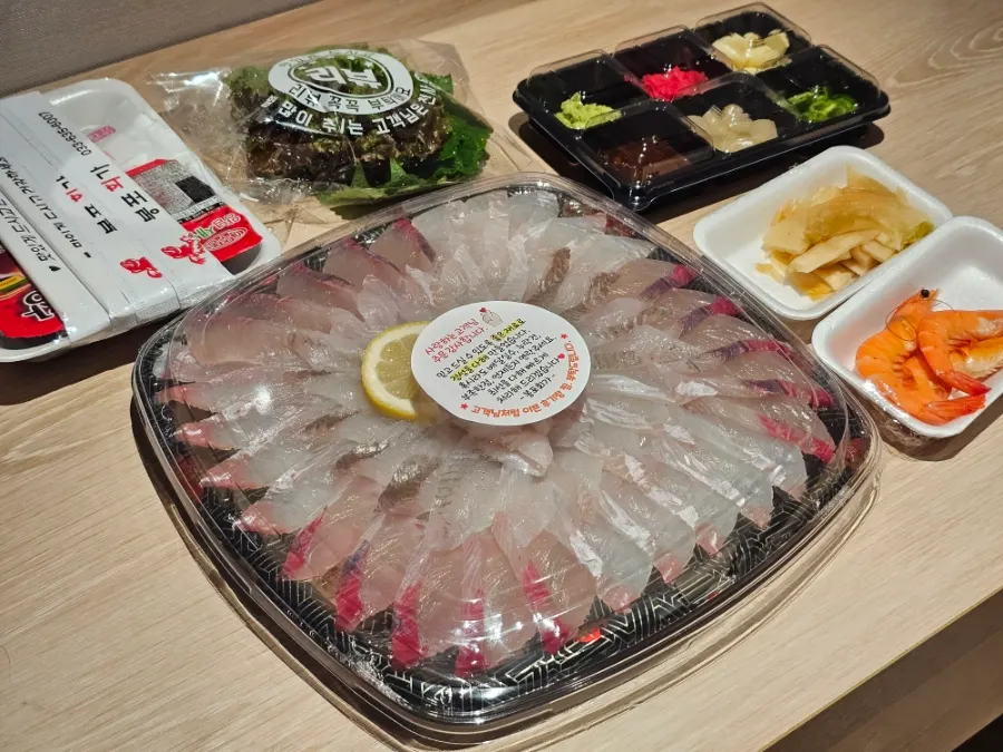 Takeout spread with assorted sashimi and side dishes