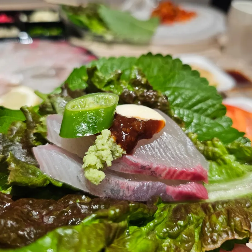 A lettuce wrap with sashimi and ssamjang