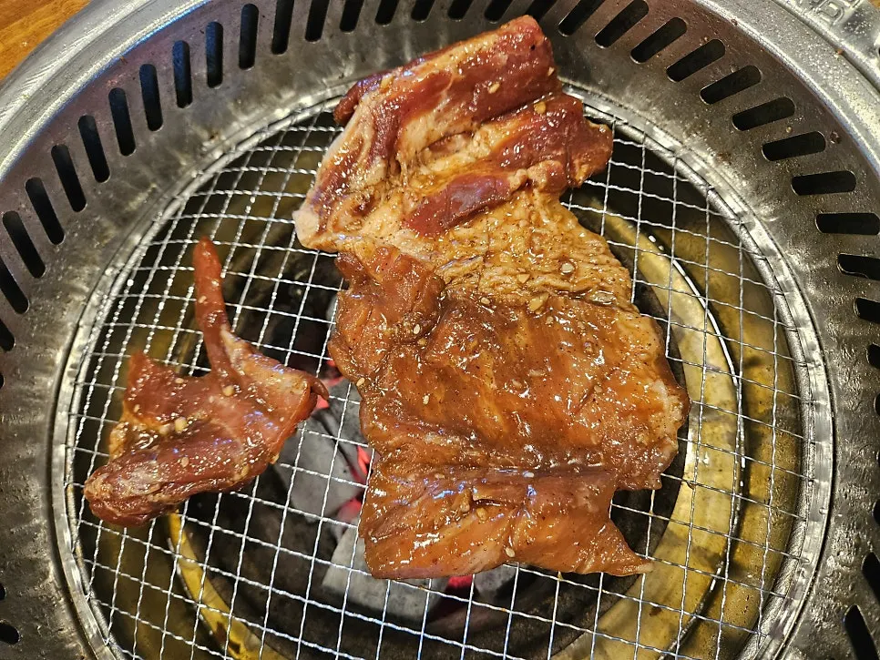 불판 위에서 구워지는 250g 돼지갈비