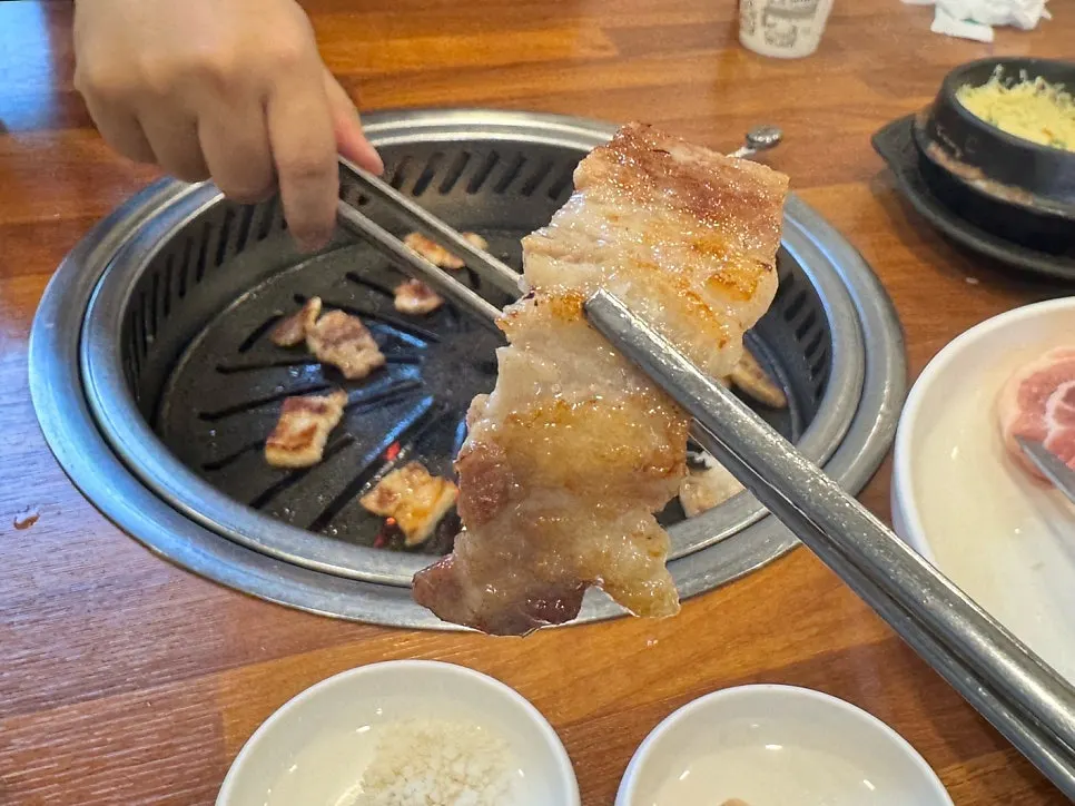 A piece of marinated pork galbi picked up with chopsticks
