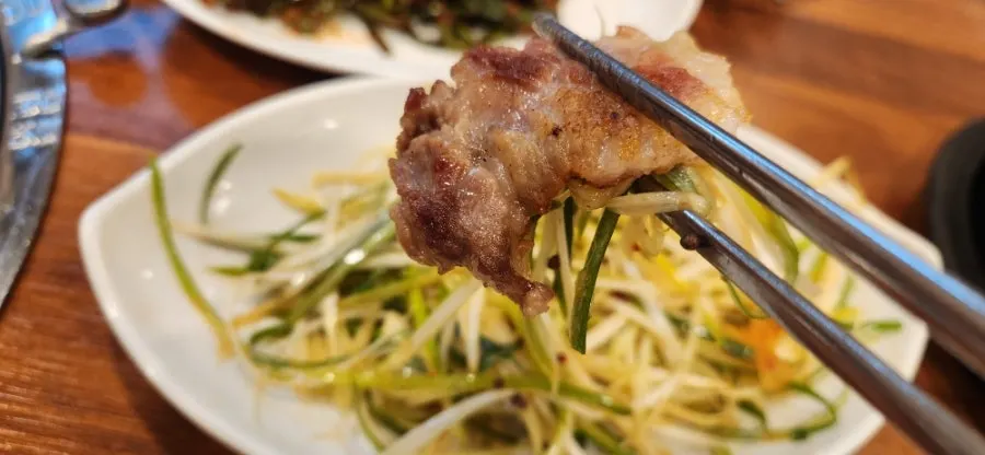 소금에 찍은 돼지갈비 한 점