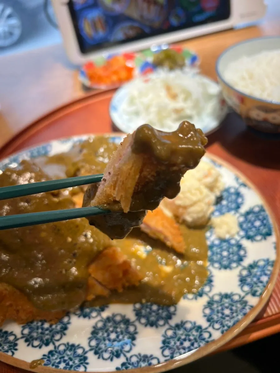 A piece of tonkatsu dipped in basil sauce