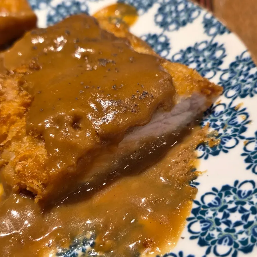 Cross-section of the thick cutlet with demi-glace sauce running down