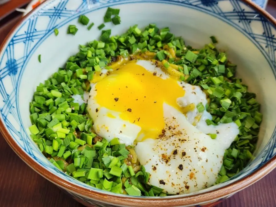 Scallions and egg yolk on top of basil soba