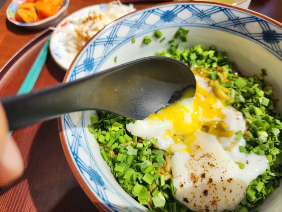 Green fresh noodles lifted with chopsticks