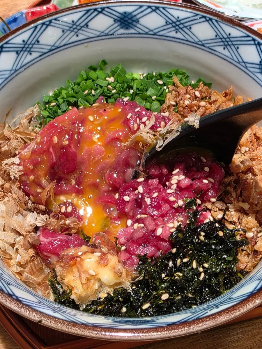 Yukhoe rice bowl topped with soy sauce blend and egg yolk