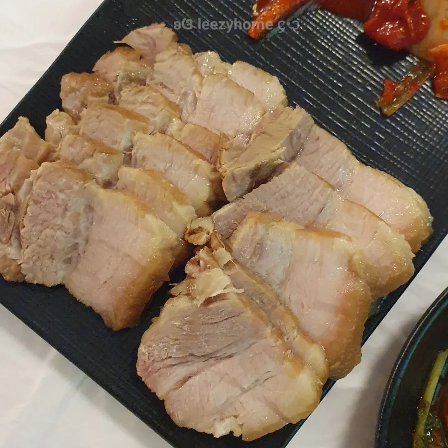 A piece of boiled pork wrapped in green onion kimchi