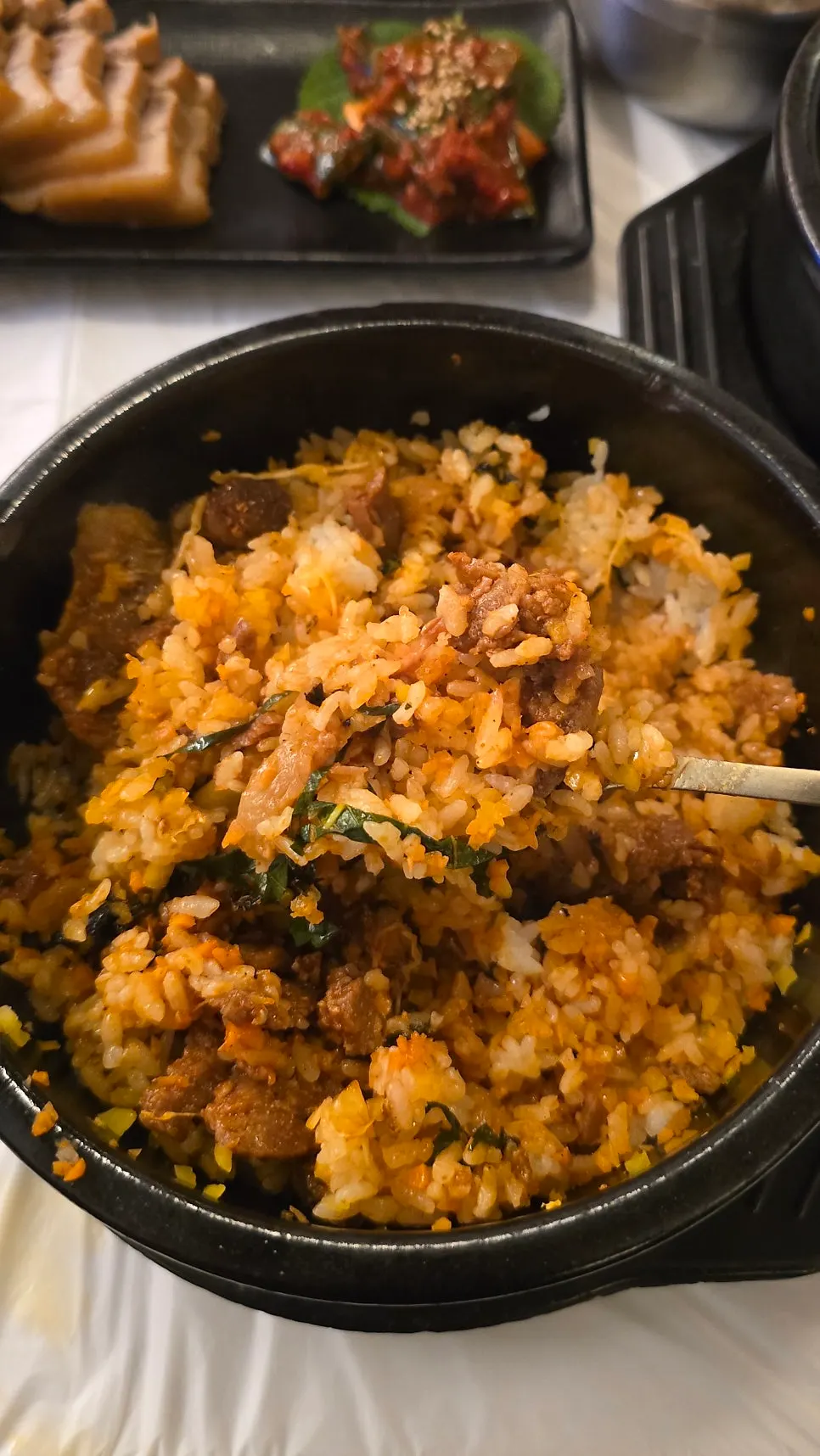 Spicy pork stone pot bibimbap topped with pork and vegetables