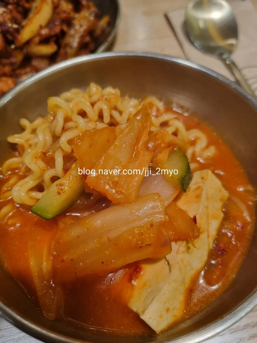 A bowl of kimchi stew with rice on the side