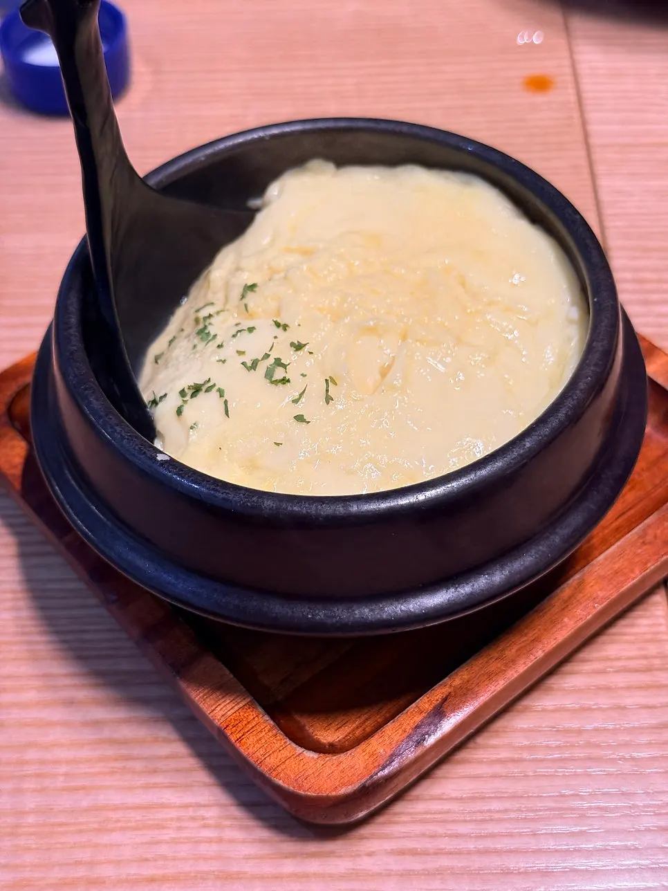 A spoonful of rice with kimchi stew and Spam on top