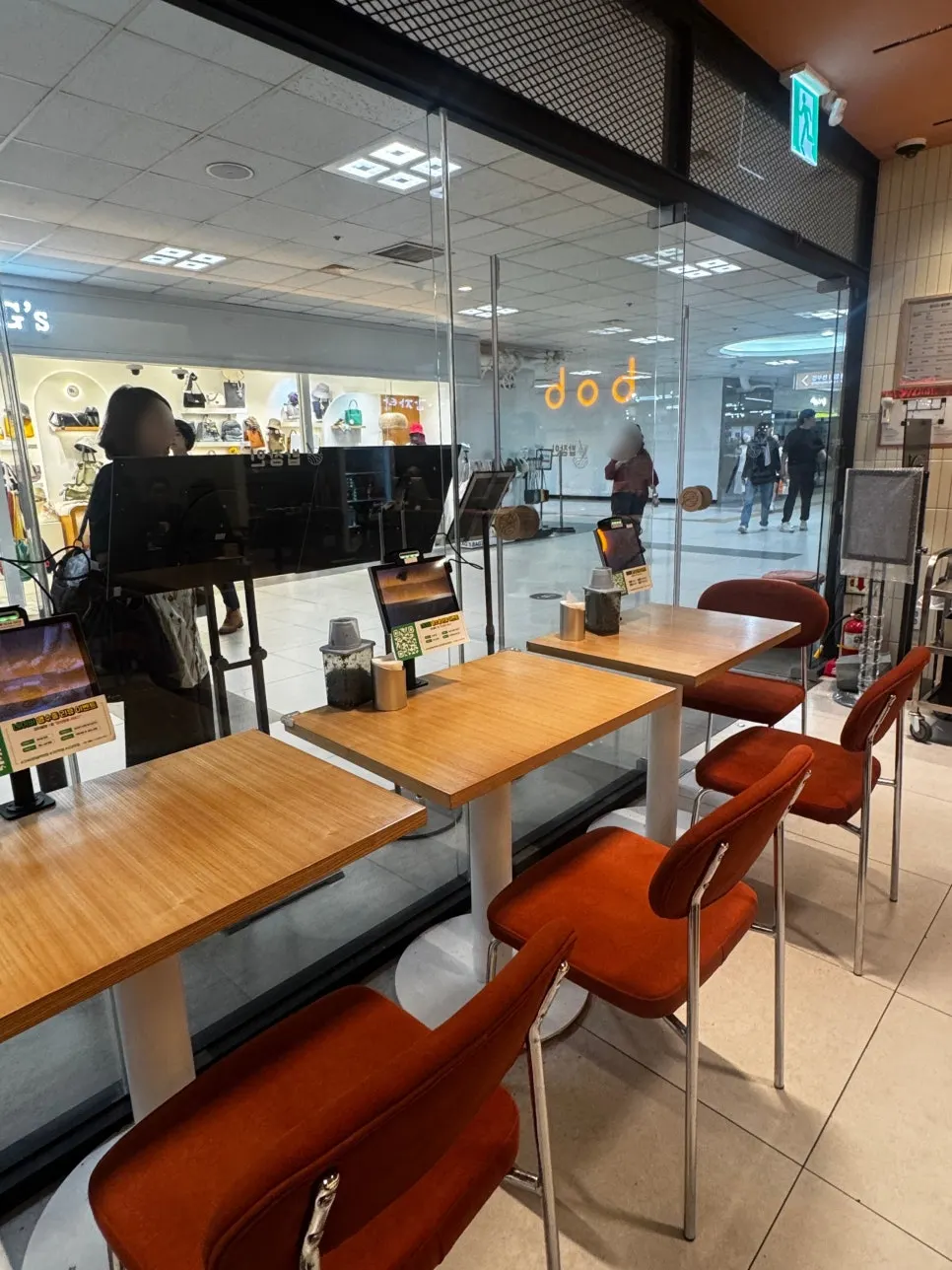 Interior with wood-tone tables and orange chairs