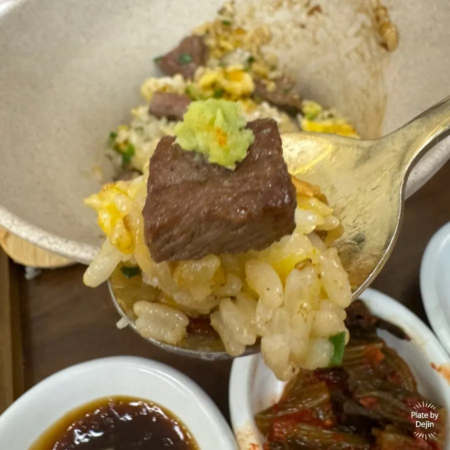 A bowl of steak pot rice with sauce soaked into the grains