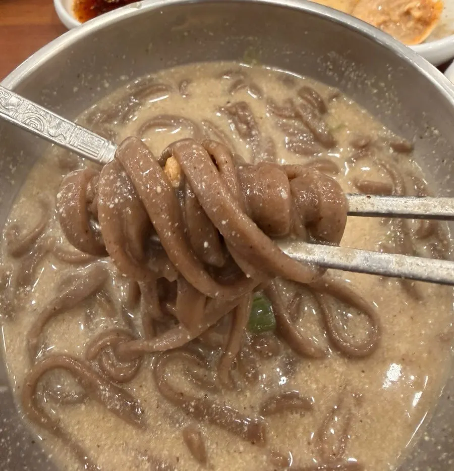 Buckwheat kalguksu noodles lifted with chopsticks