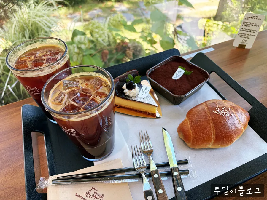 Table setting with Basque cheesecake, tiramisu, and an Americano
