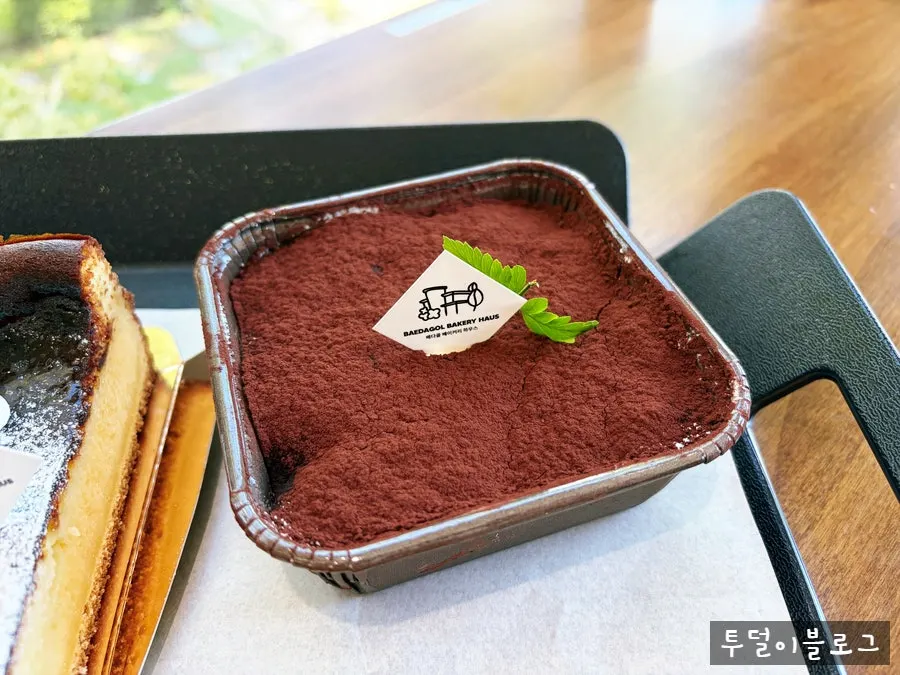 A spoonful of tiramisu with an Americano