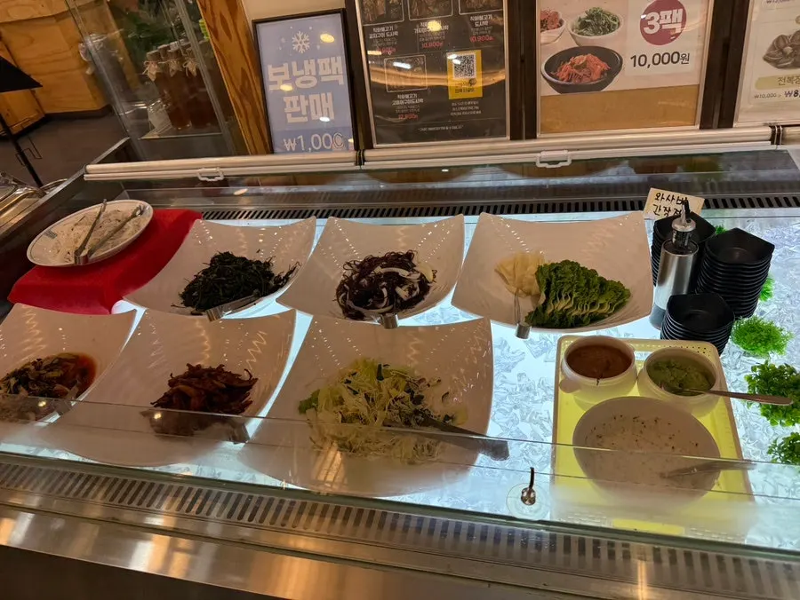 Banchan containers and tongs at the self-bar