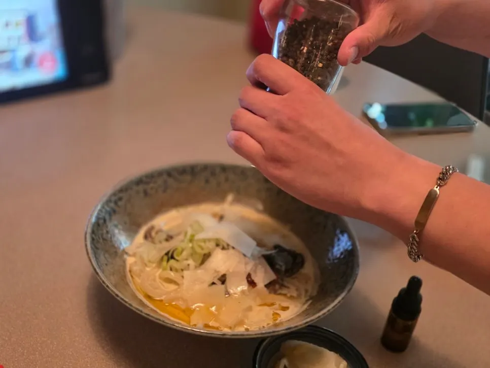 Perilla cream udon topped with cheese powder and scallions