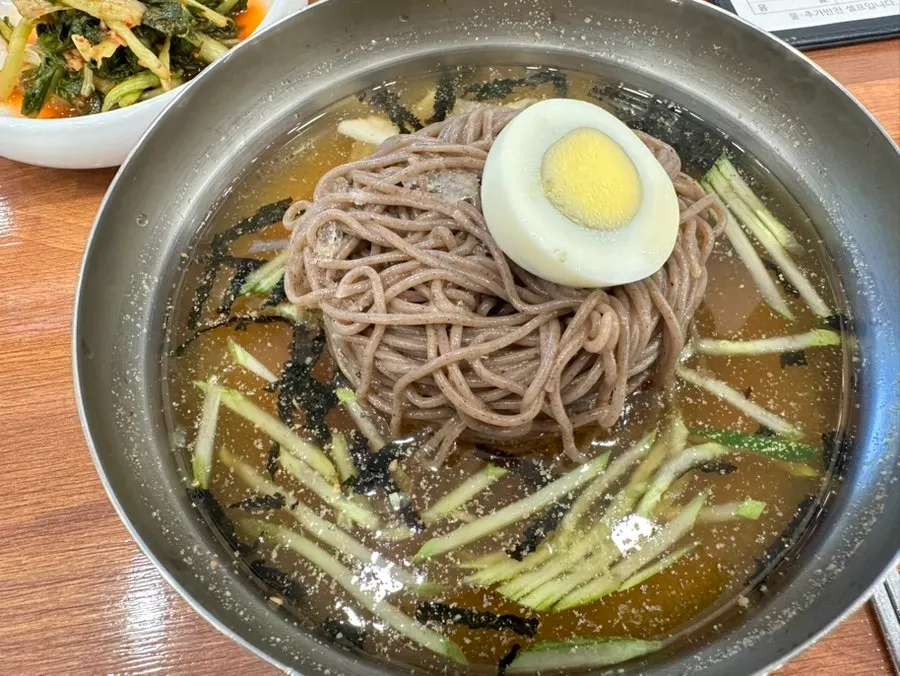 Bowl of bibim-makguksu topped generously with sesame seeds