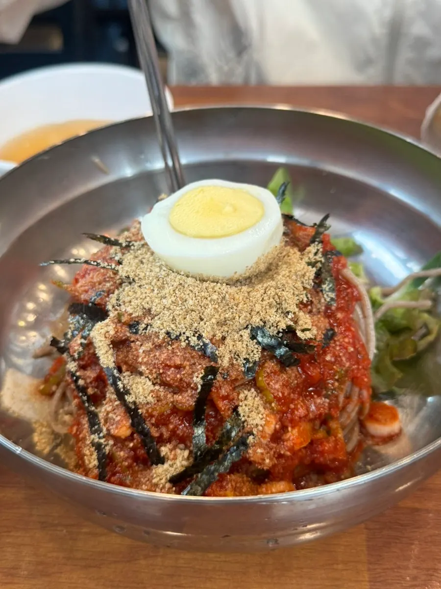 Bibim makguksu topped with lettuce and cucumber