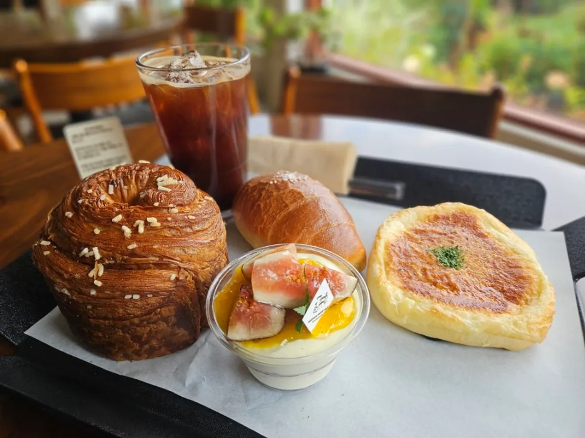 Salt bread, mont blanc, tomato ham cheese bread and an Americano on the table