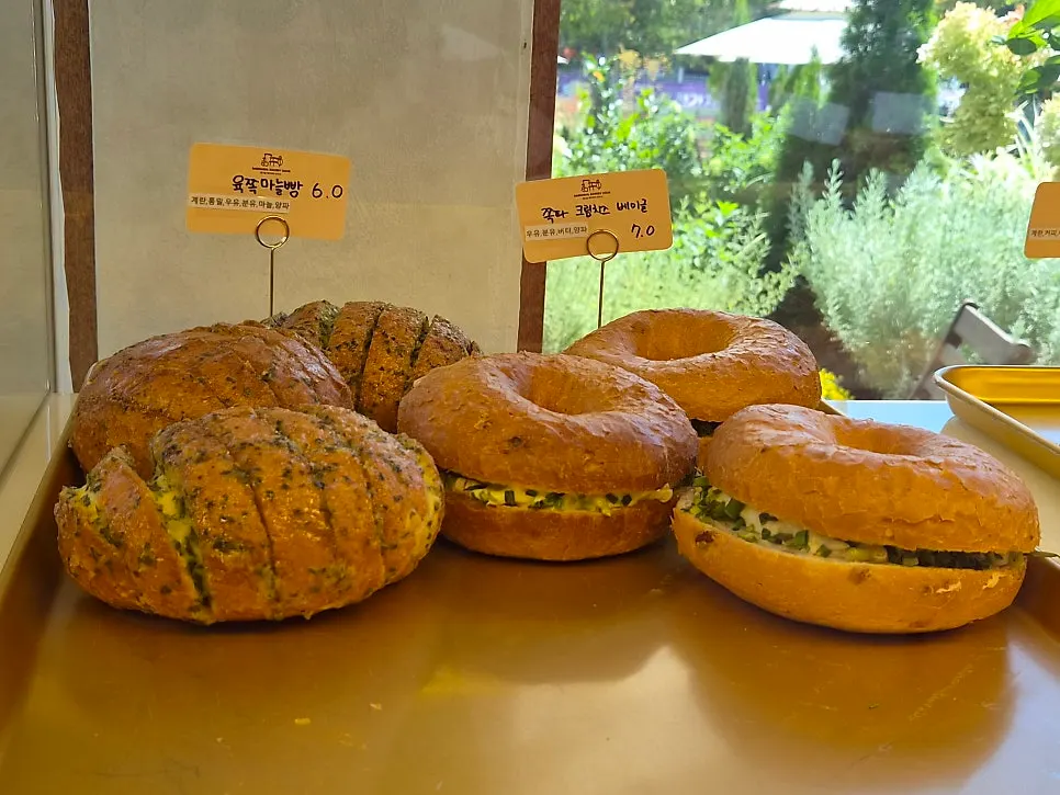 Six-clove garlic bread and scallion cream cheese bagel on display