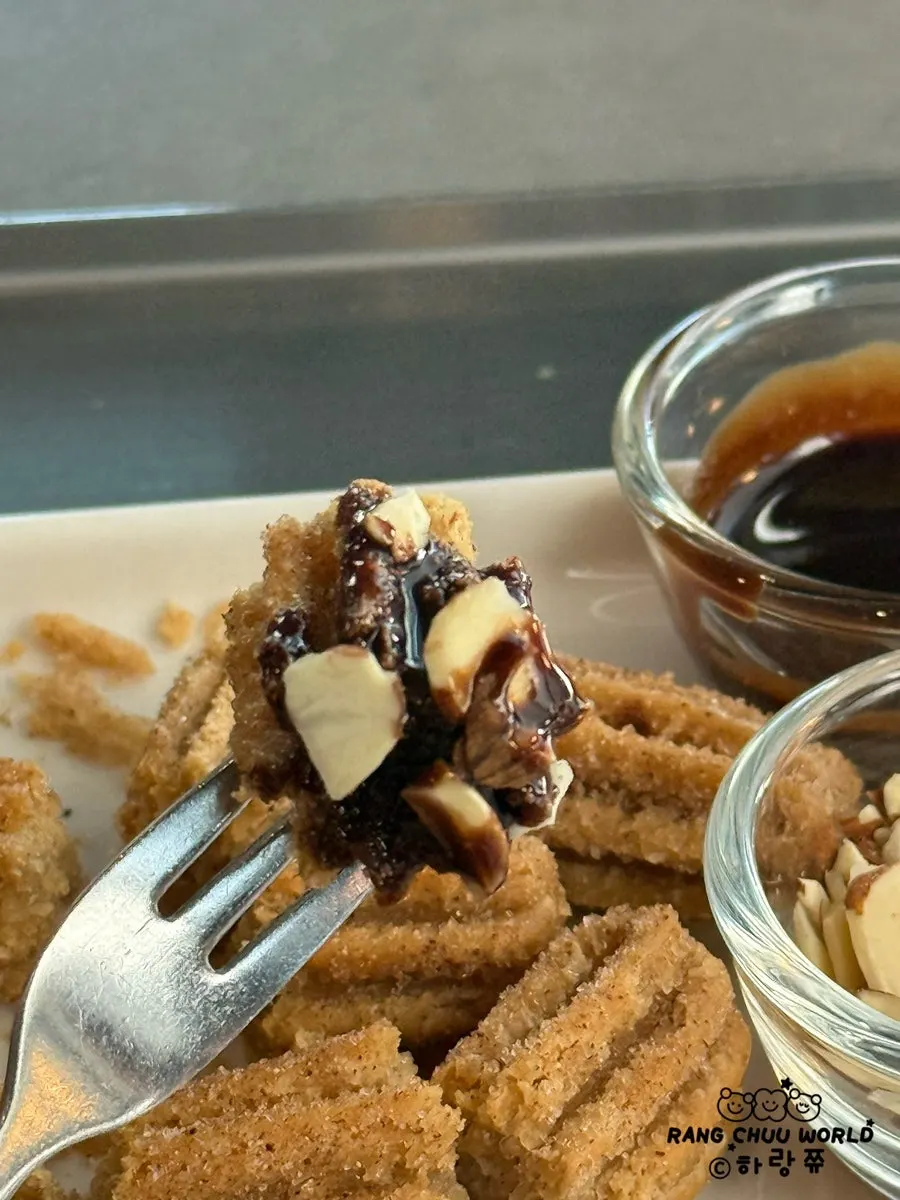 Churros yang baru digoreng bersama choco dipping dan badam