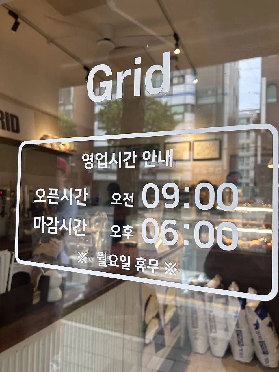 문 앞에 붙은 그리드 카페 영업시간 안내