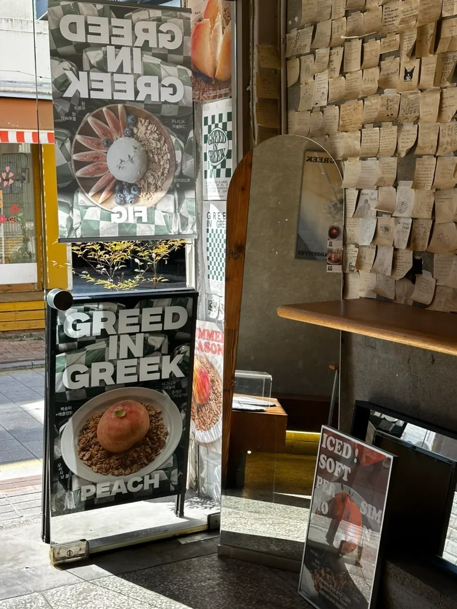 Grid in Greek entrance with business hours sign