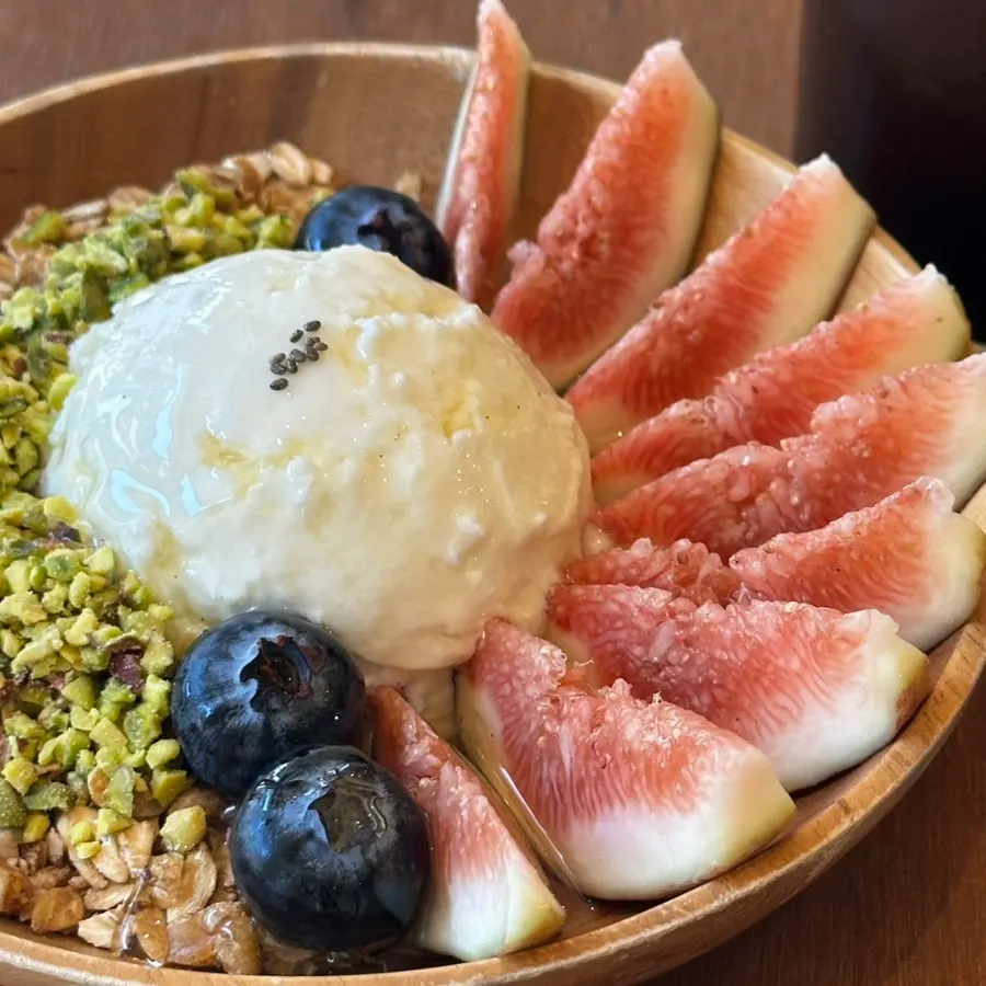 Yogurt bowl topped with fig, blueberries, and honey