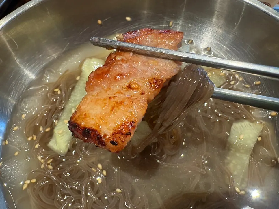 A piece of pork belly dipped in sauce