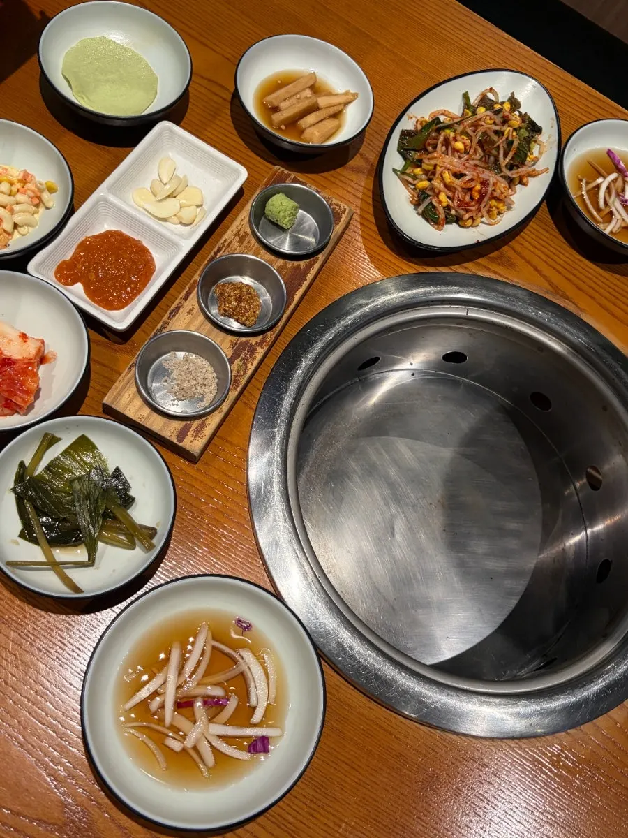 Spread of side dishes including bean sprout salad and myeong-i namul