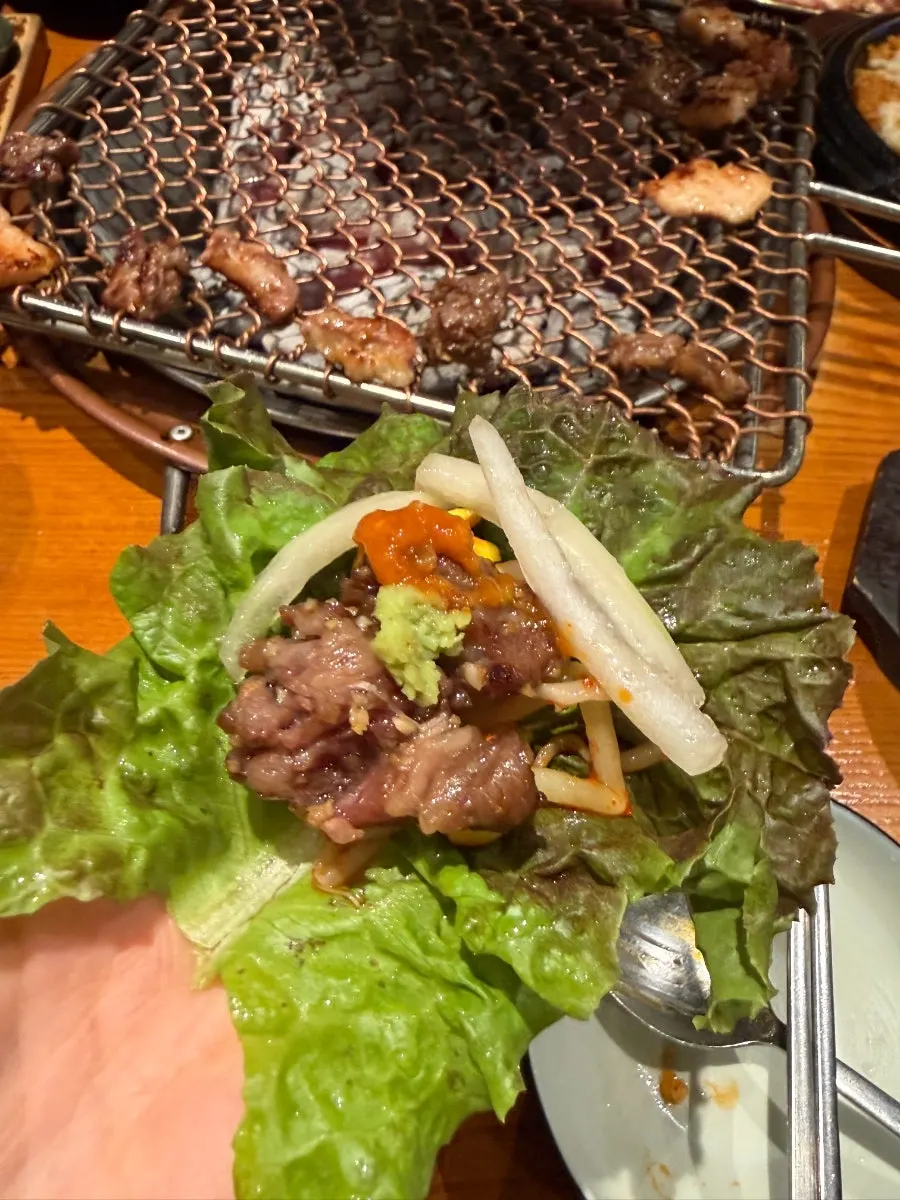 Garlic-marinated meat placed on wrap greens
