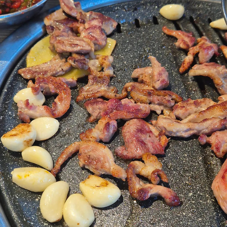 Raw duck grilling over charcoal