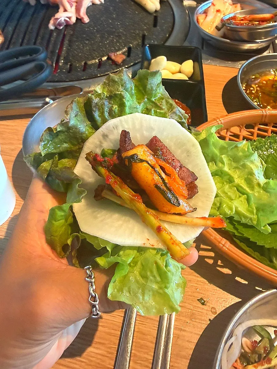 A duck wrap with fresh greens and side dishes