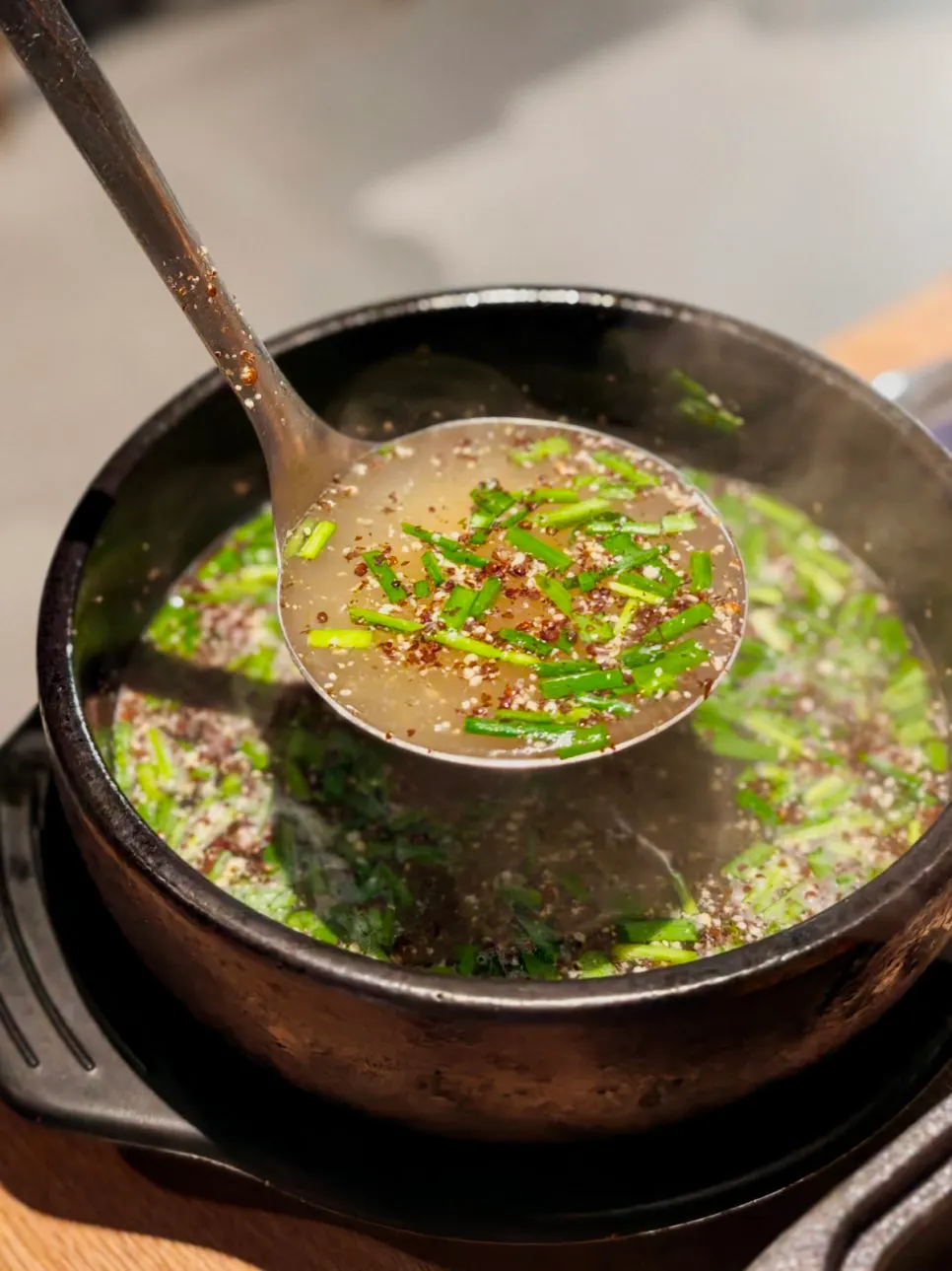 Duck hotpot broth ladled into a bowl
