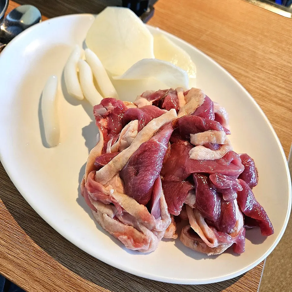 Raw duck loin served with potatoes and rice cakes