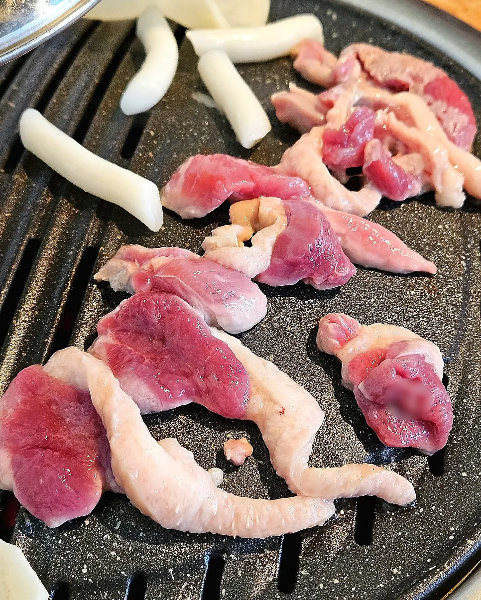 Raw duck grilling over charcoal