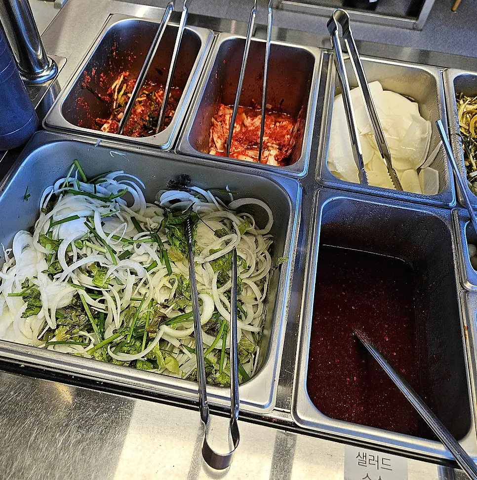 Kimchi and pickled side dishes at the self-serve bar